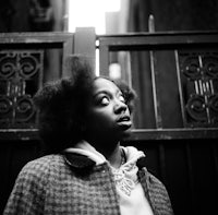 a black and white photo of a woman with afro hair