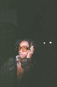a woman wearing glasses and a plaid jacket