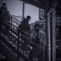 a group of people walking up the stairs at a train station