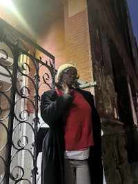 a woman is talking on a cell phone in front of a building