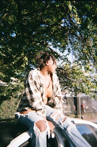 a woman sitting on the hood of a car